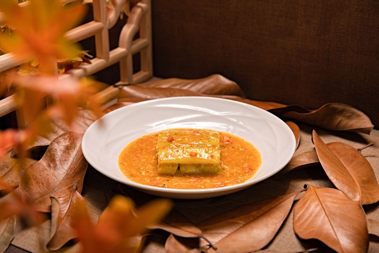 The Art of Drawing Readers In: Your attractive post title goes here A fusion dish garnished with autumn leaves in a rustic indoor setting, perfect for seasonal cuisine.